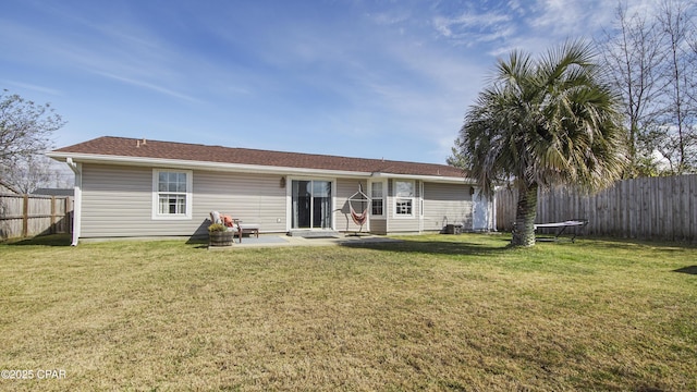 rear view of property featuring fence private yard, a patio area, and a lawn