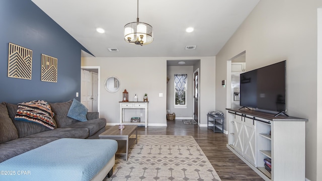 living area featuring dark wood-style floors, an inviting chandelier, visible vents, and baseboards