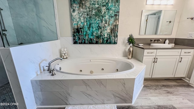 full bath featuring a jetted tub and vanity