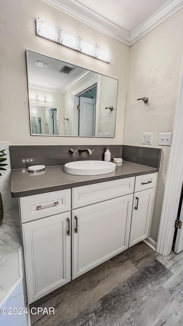 bathroom featuring visible vents, ornamental molding, and vanity