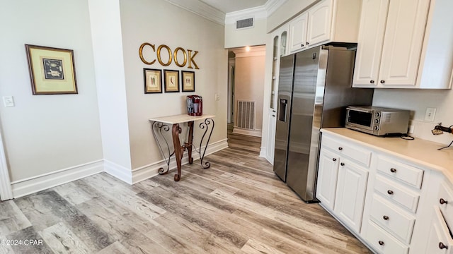 kitchen featuring white cabinetry, visible vents, and stainless steel fridge with ice dispenser