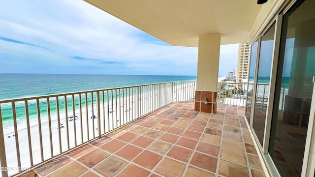 balcony with a water view and a view of the beach