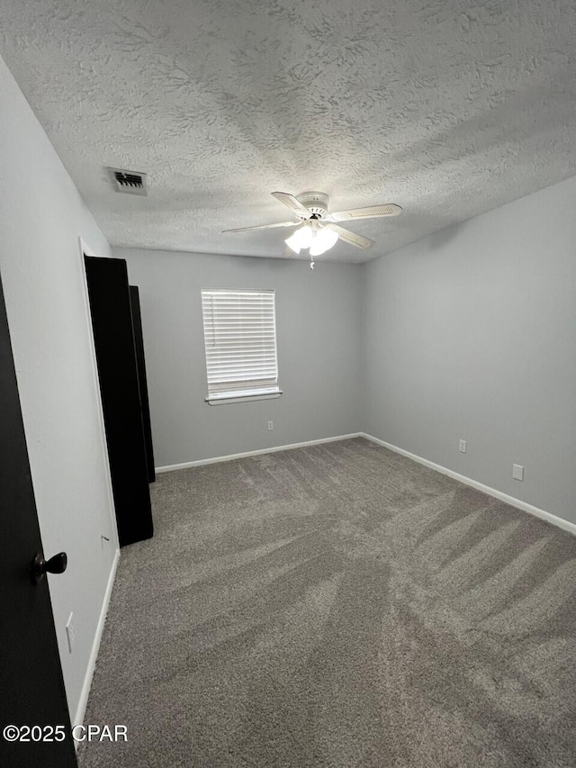 empty room with visible vents, ceiling fan, baseboards, and carpet