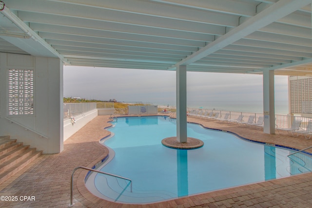 community pool with a patio and fence