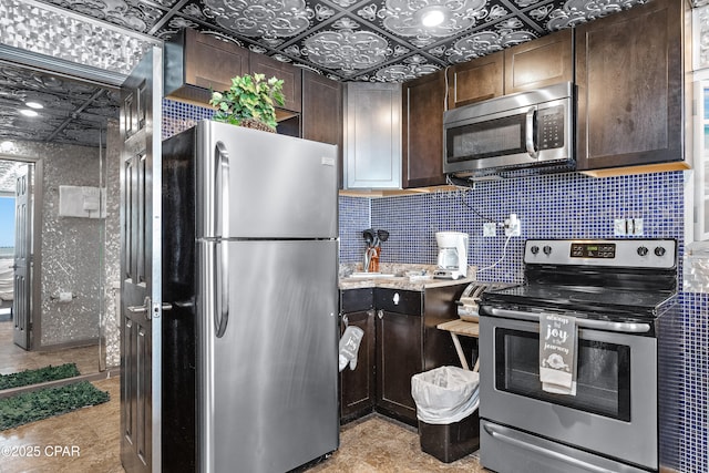 kitchen with appliances with stainless steel finishes, dark brown cabinets, decorative backsplash, and an ornate ceiling