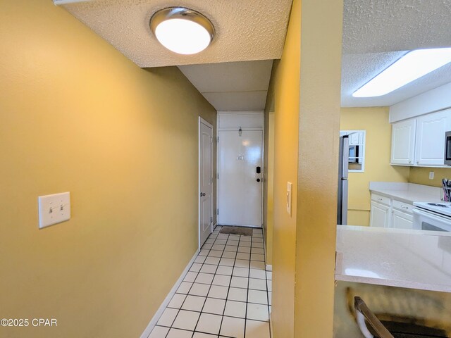 kitchen featuring white cabinetry, light countertops, white electric range, and light tile patterned flooring