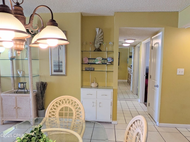 dining area with baseboards, a textured ceiling, and light tile patterned flooring