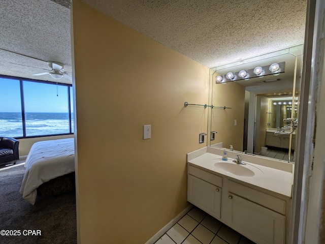 bathroom featuring a textured ceiling, ensuite bath, vanity, and tile patterned floors