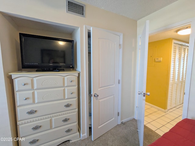 room details featuring a textured ceiling, carpet floors, visible vents, and baseboards