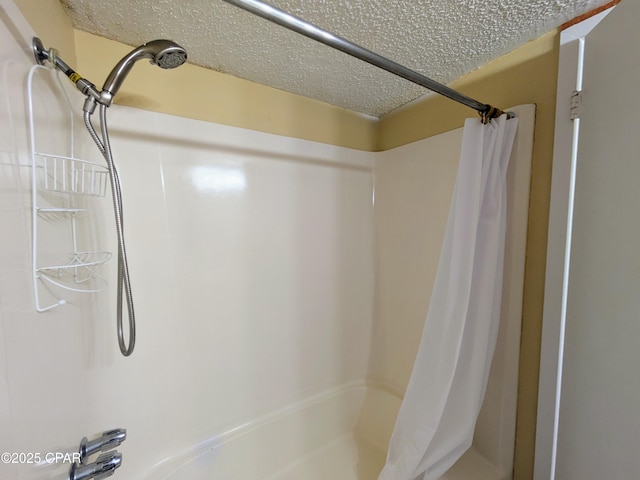 bathroom with a textured ceiling and shower / tub combo