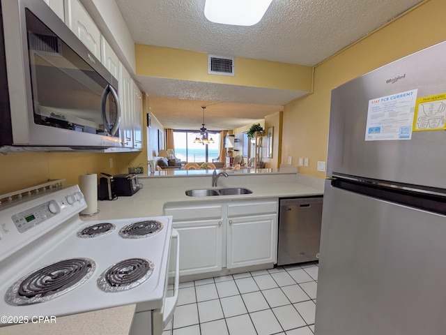 kitchen featuring visible vents, stainless steel appliances, a sink, and light countertops