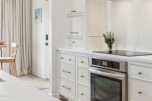 bar with stainless steel oven and black electric cooktop