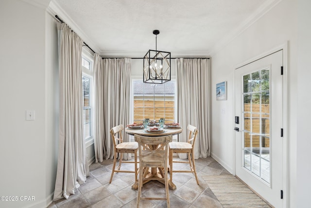 dining area featuring a notable chandelier, crown molding, a textured ceiling, and baseboards