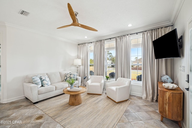 living room featuring baseboards, ornamental molding, visible vents, and a ceiling fan