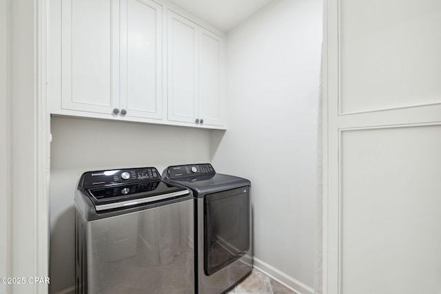 laundry room with baseboards, tile patterned floors, cabinet space, and washer and dryer