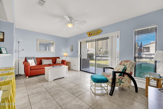 living area featuring light tile patterned floors, visible vents, and a ceiling fan