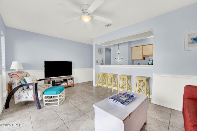 living area featuring light tile patterned floors, visible vents, and a ceiling fan