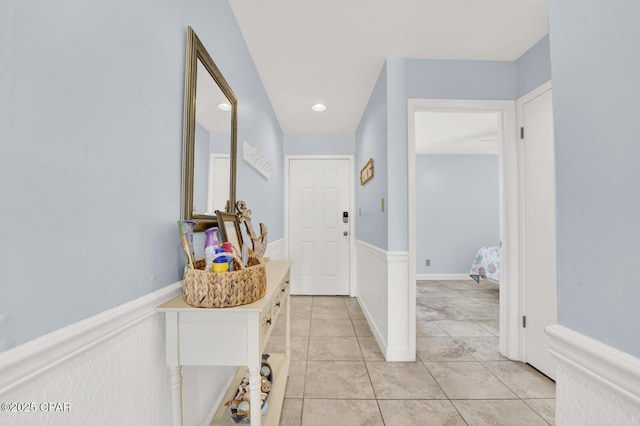 corridor with light tile patterned floors and wainscoting