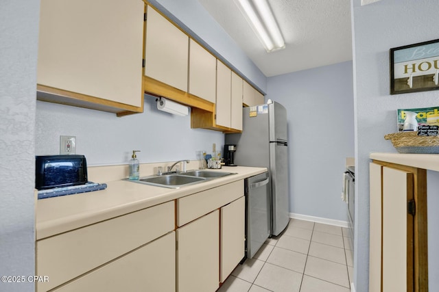 kitchen featuring a sink, stainless steel dishwasher, a textured ceiling, light countertops, and light tile patterned floors