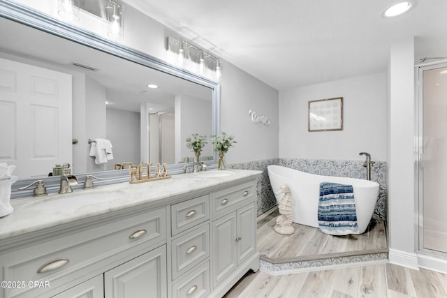 bathroom featuring double vanity, a stall shower, visible vents, and a sink