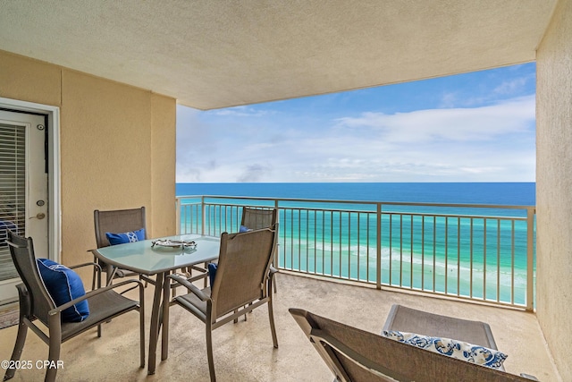 balcony featuring a water view and outdoor dining area