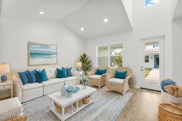 living room with light wood-style flooring, recessed lighting, and high vaulted ceiling
