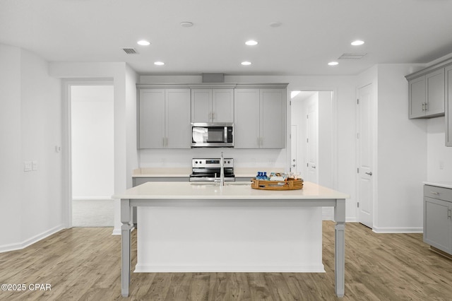 kitchen with a sink, light countertops, gray cabinetry, and stainless steel appliances