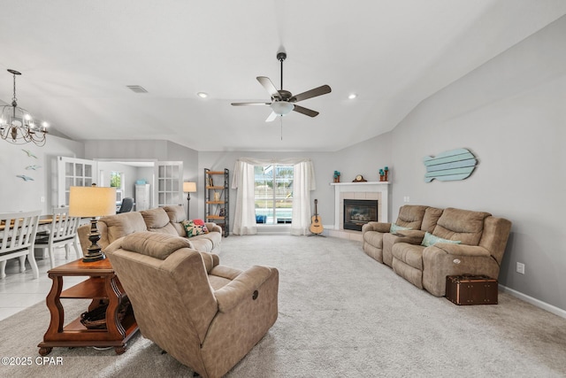 living area with carpet floors, baseboards, vaulted ceiling, and a tiled fireplace