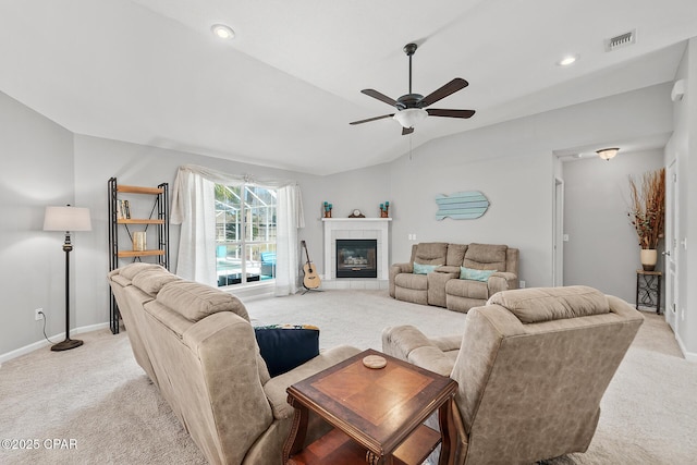 living room with light carpet, visible vents, a ceiling fan, vaulted ceiling, and a fireplace