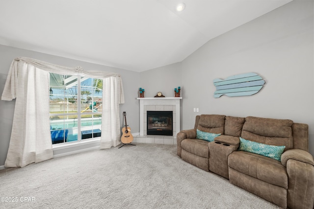 carpeted living area featuring lofted ceiling and a tiled fireplace