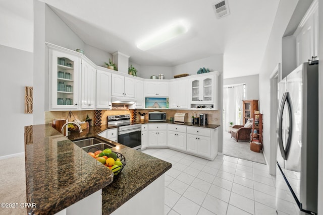 kitchen with glass insert cabinets, appliances with stainless steel finishes, decorative backsplash, and a sink