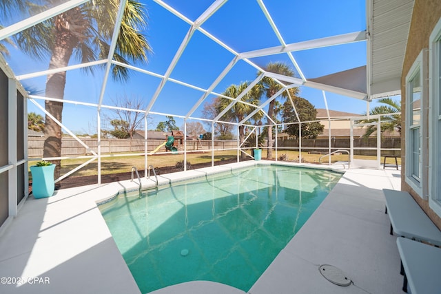 view of pool with a playground, a patio area, a fenced backyard, and a lanai