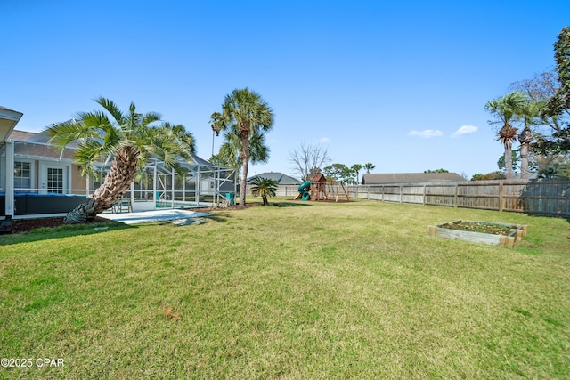 view of yard featuring a vegetable garden, glass enclosure, a playground, and fence