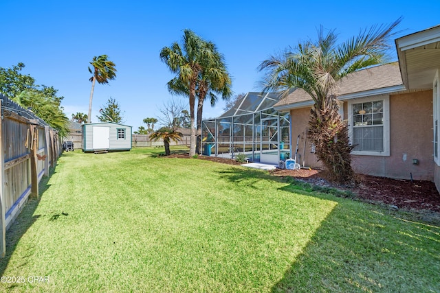 view of yard featuring a storage shed, glass enclosure, an outdoor structure, and a fenced backyard