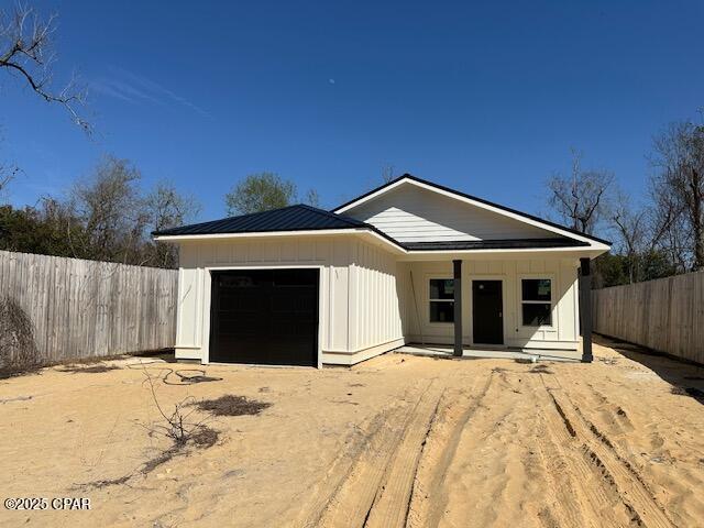 view of front facade featuring an attached garage, fence, and board and batten siding