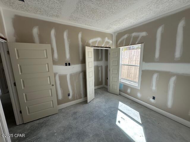 unfurnished bedroom featuring a textured ceiling and a closet