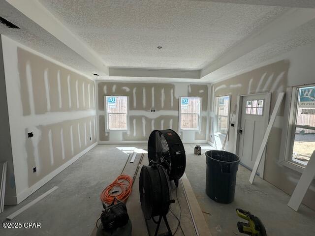 interior space featuring a textured ceiling and a tray ceiling