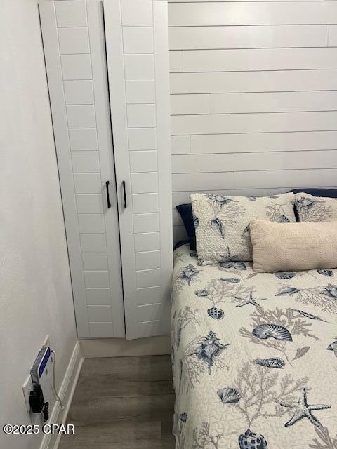 bedroom with wood finished floors and baseboards