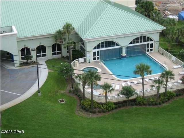 community pool with a lawn, a patio area, and a hot tub