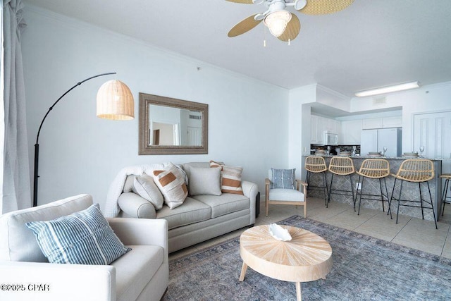 living area featuring light tile patterned floors, ceiling fan, and ornamental molding