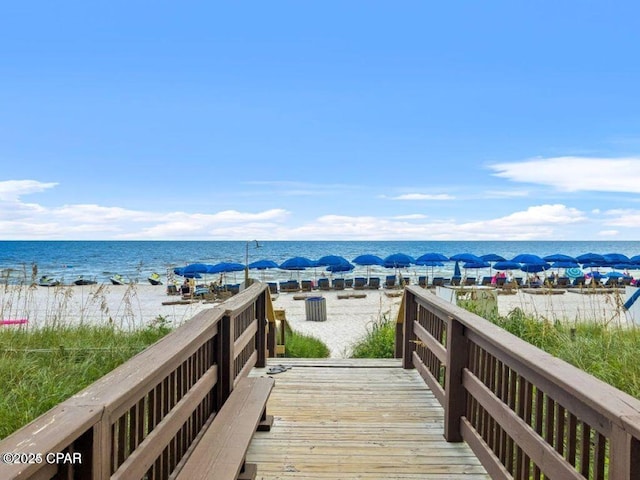 view of property's community featuring a beach view and a water view