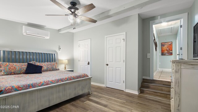 bedroom with an AC wall unit, ceiling fan, baseboards, and wood finished floors