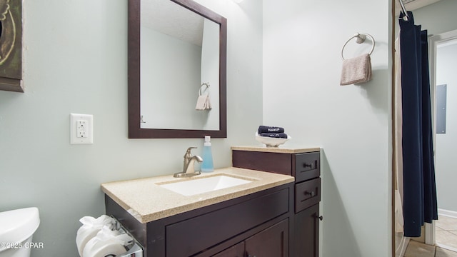 bathroom with toilet, a textured ceiling, vanity, and tile patterned floors