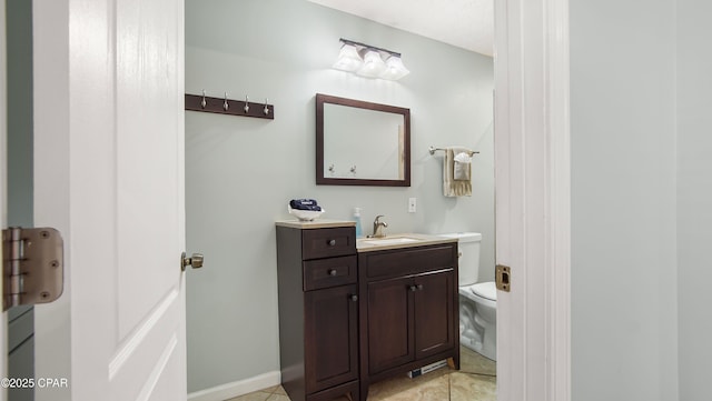 bathroom featuring tile patterned flooring, baseboards, vanity, and toilet