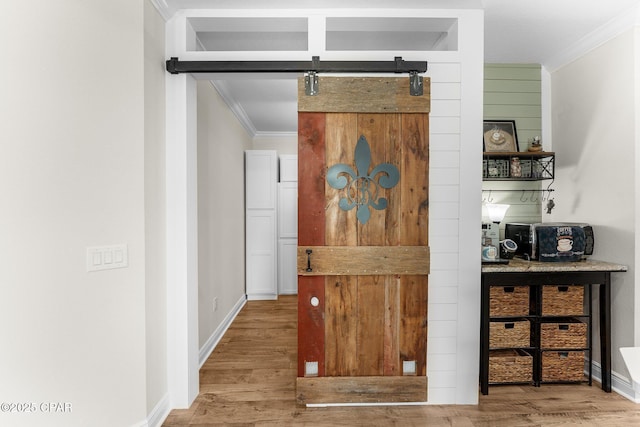 bar with wood finished floors, crown molding, and a barn door