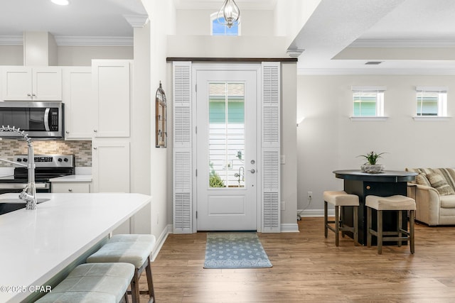 entrance foyer featuring crown molding and plenty of natural light