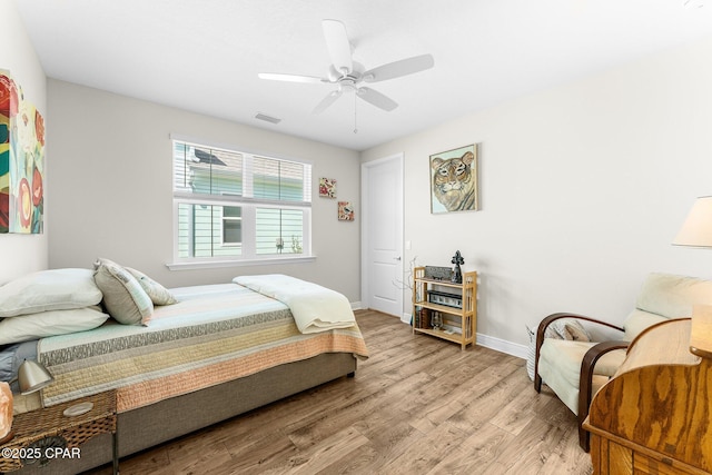 bedroom with visible vents, ceiling fan, baseboards, and wood finished floors