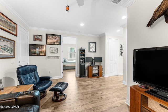 interior space with baseboards, light wood-style flooring, visible vents, and crown molding