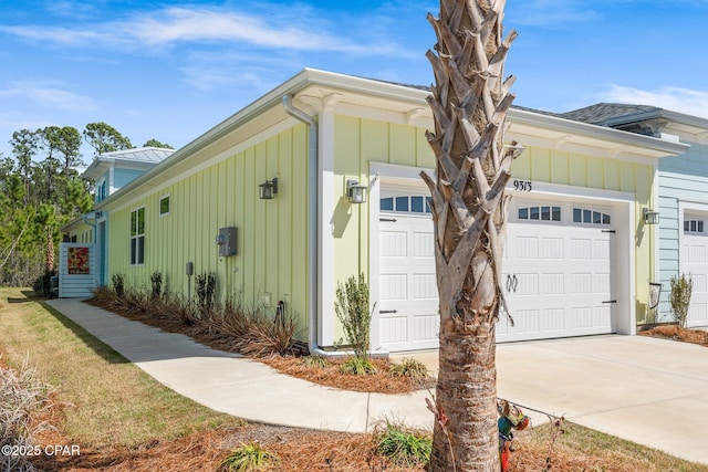 view of side of property with an attached garage, driveway, and board and batten siding