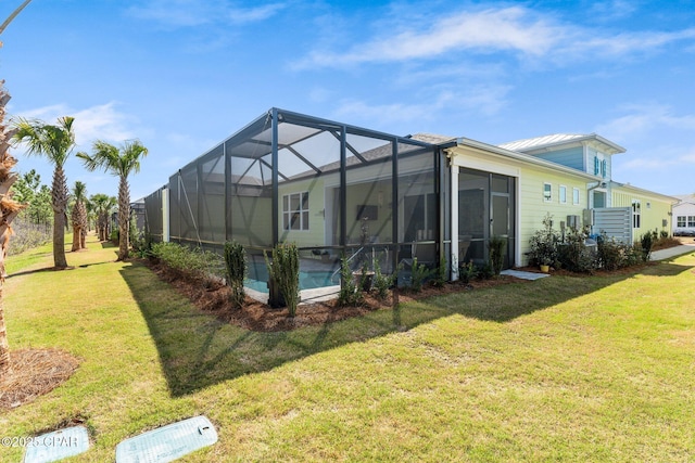 back of house with glass enclosure, metal roof, an outdoor pool, and a lawn